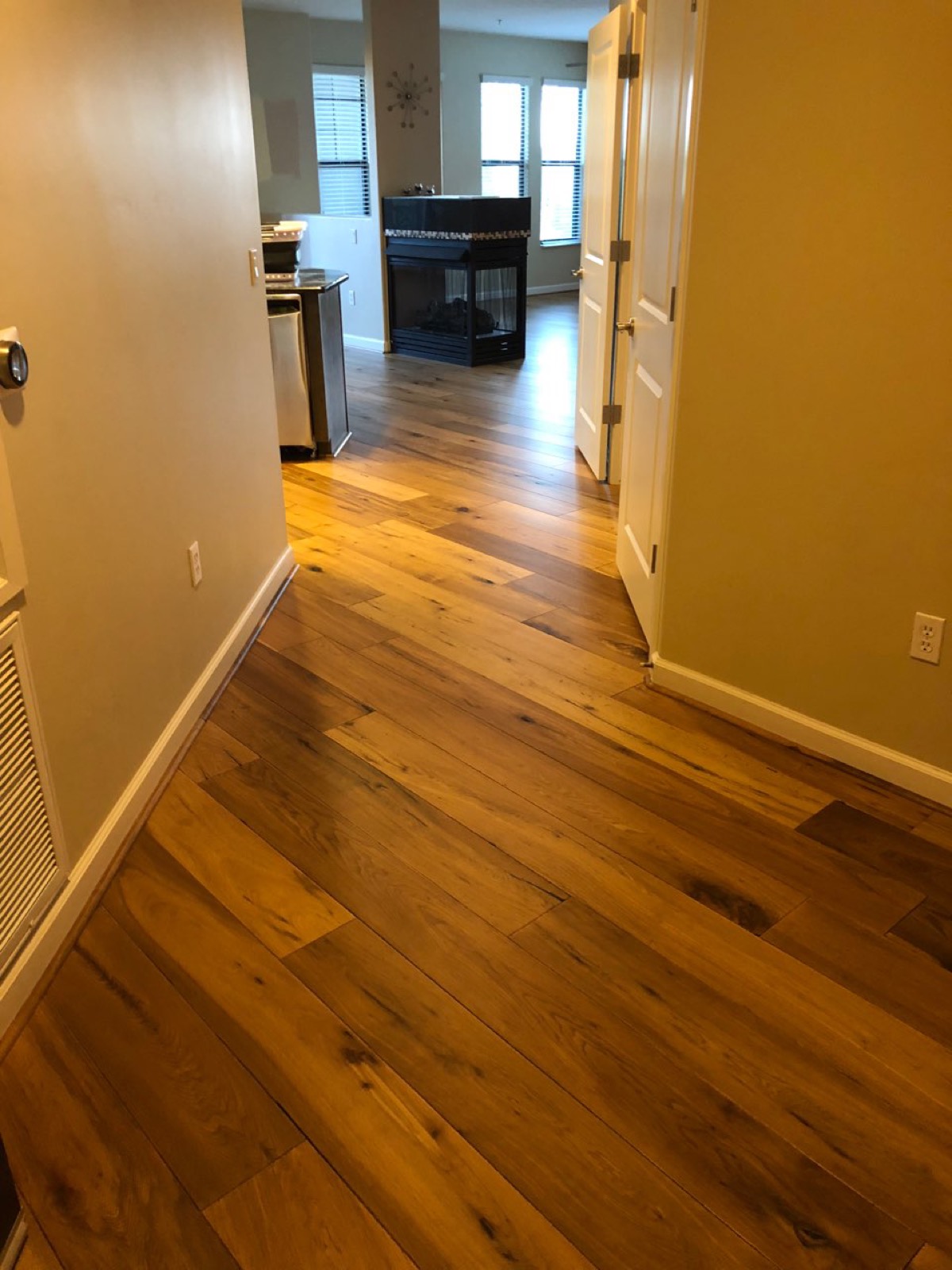 Hand-scraped hickory flooring through a hallway and kitchen