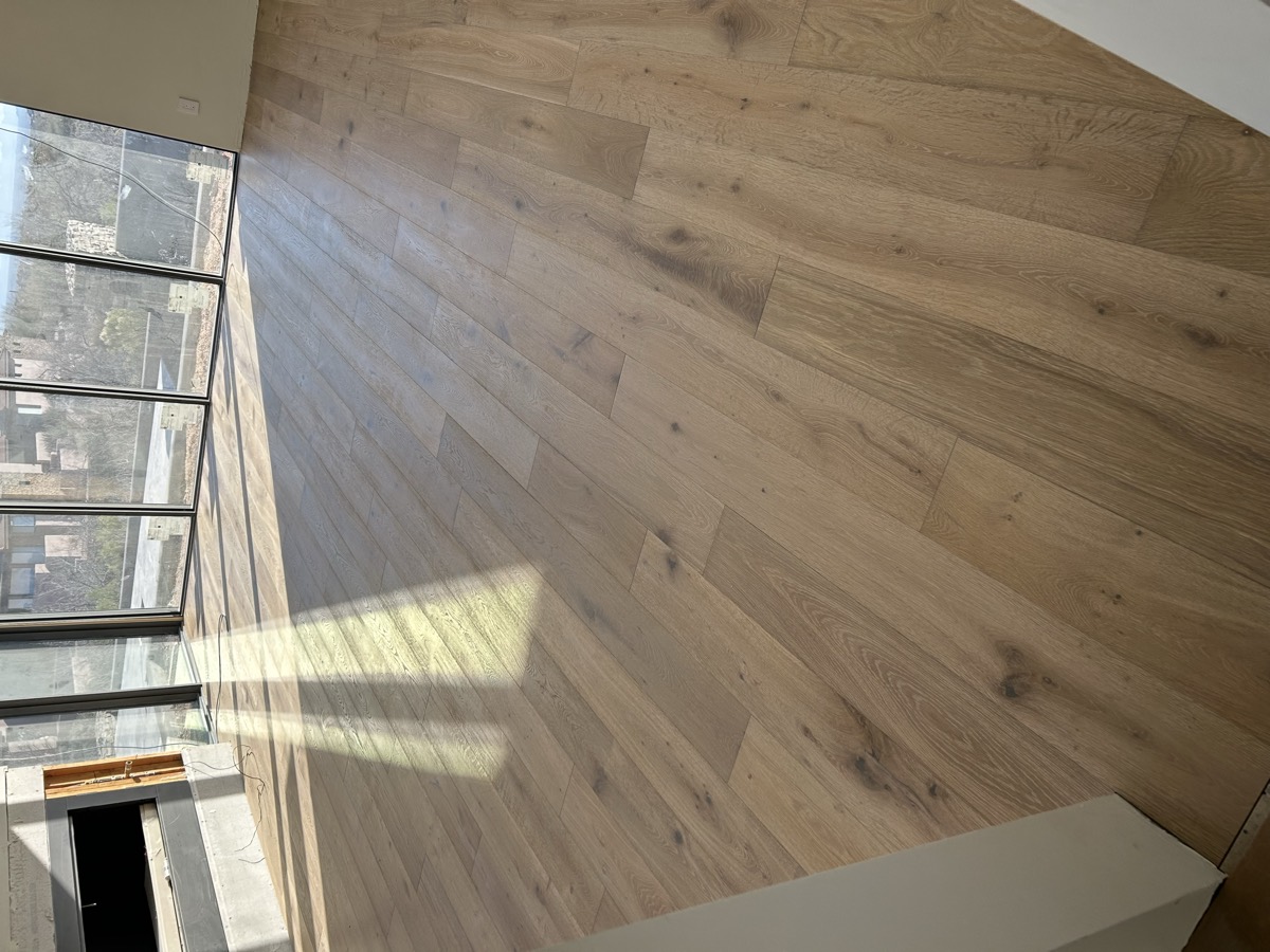 Wide plank flooring in a living room with mountain views